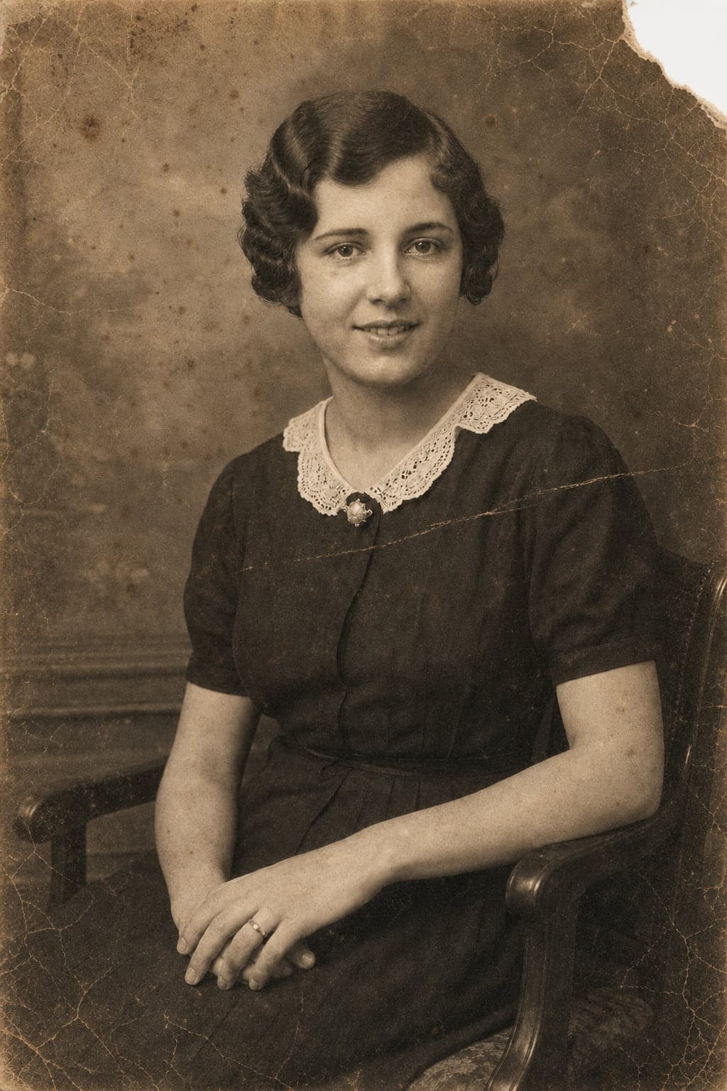 A creased, stained and torn 1930s studio portrait of a young woman